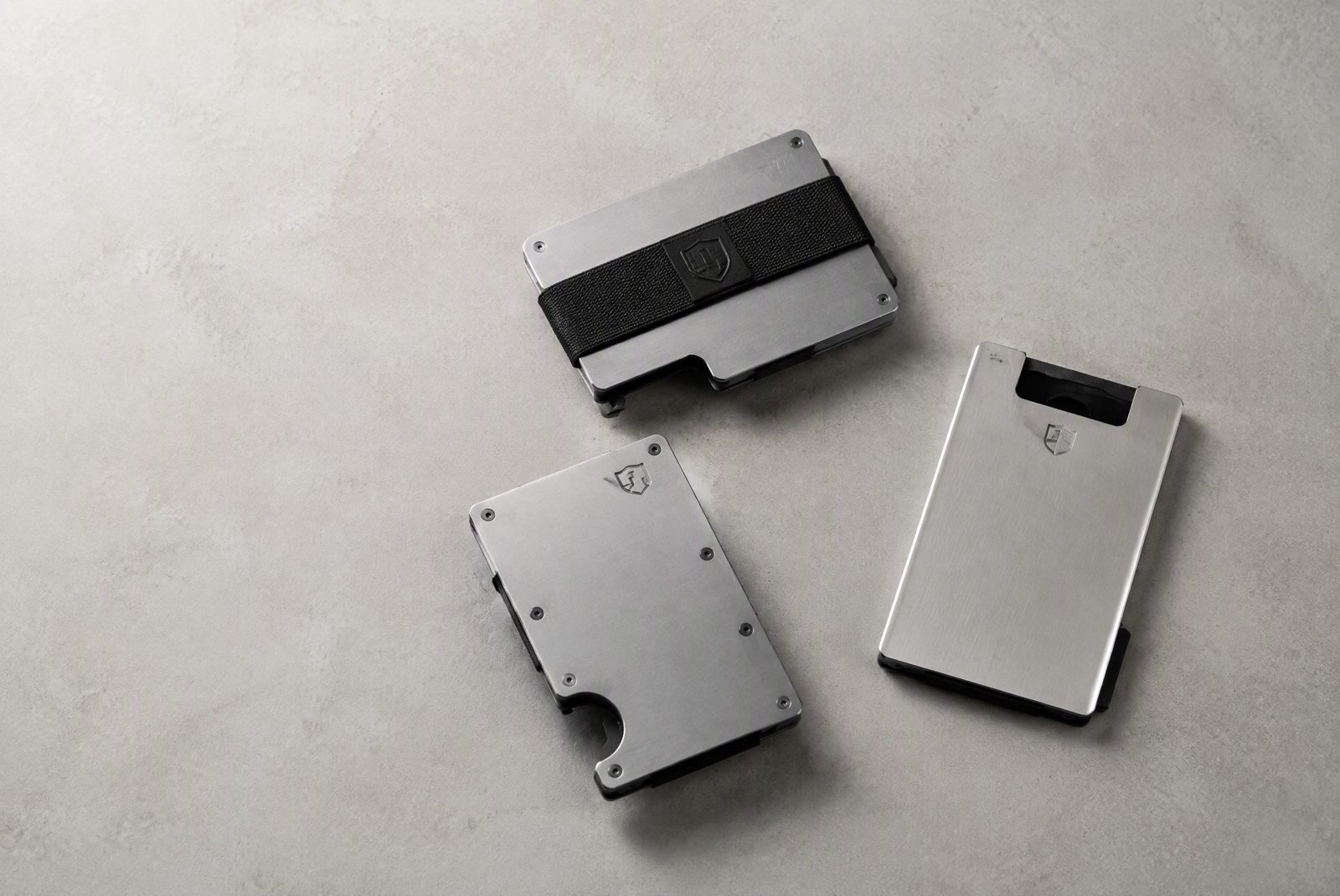 Slim aluminum wallet in machined finish next to an EDC carry setup, studio product photography