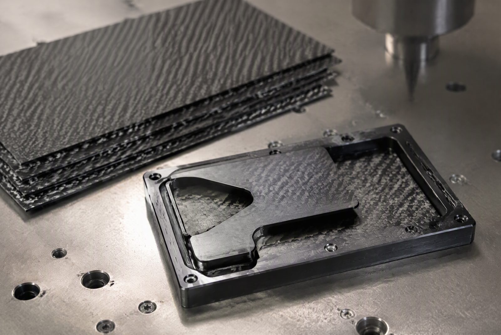 Two carbon fiber wallet shells next to an aerospace aluminum frame