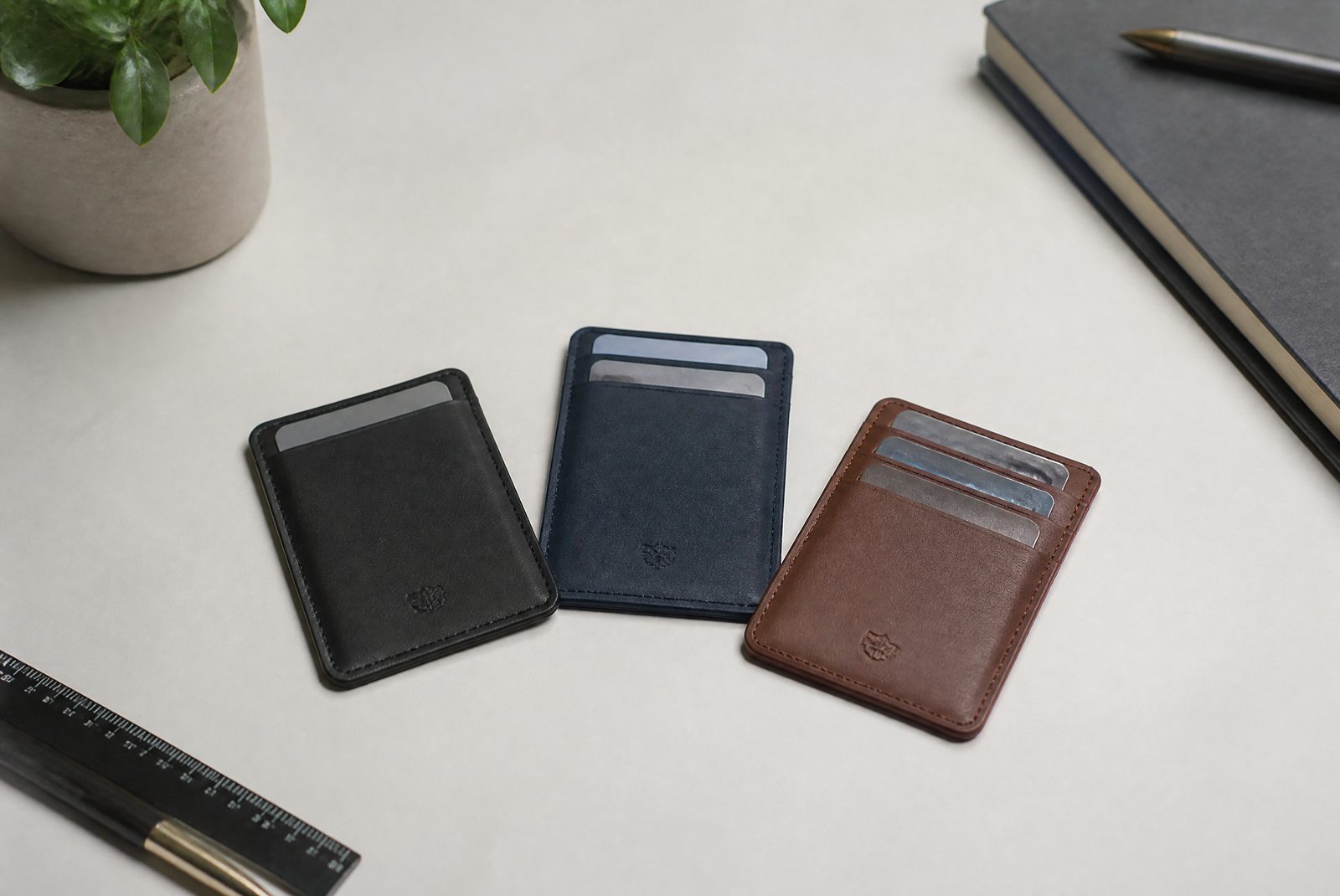 Compact EDC wallet with cards fanned out and a key clip, showing thin profile