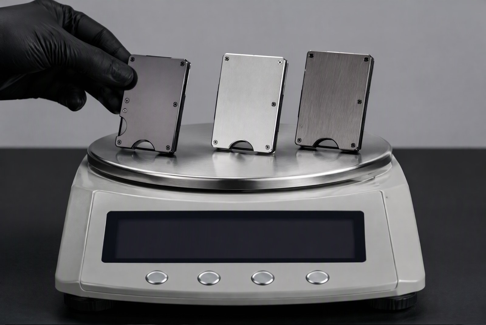 comparison: thickness and weight comparison of several titanium wallets against a credit card, studio macro, product photography