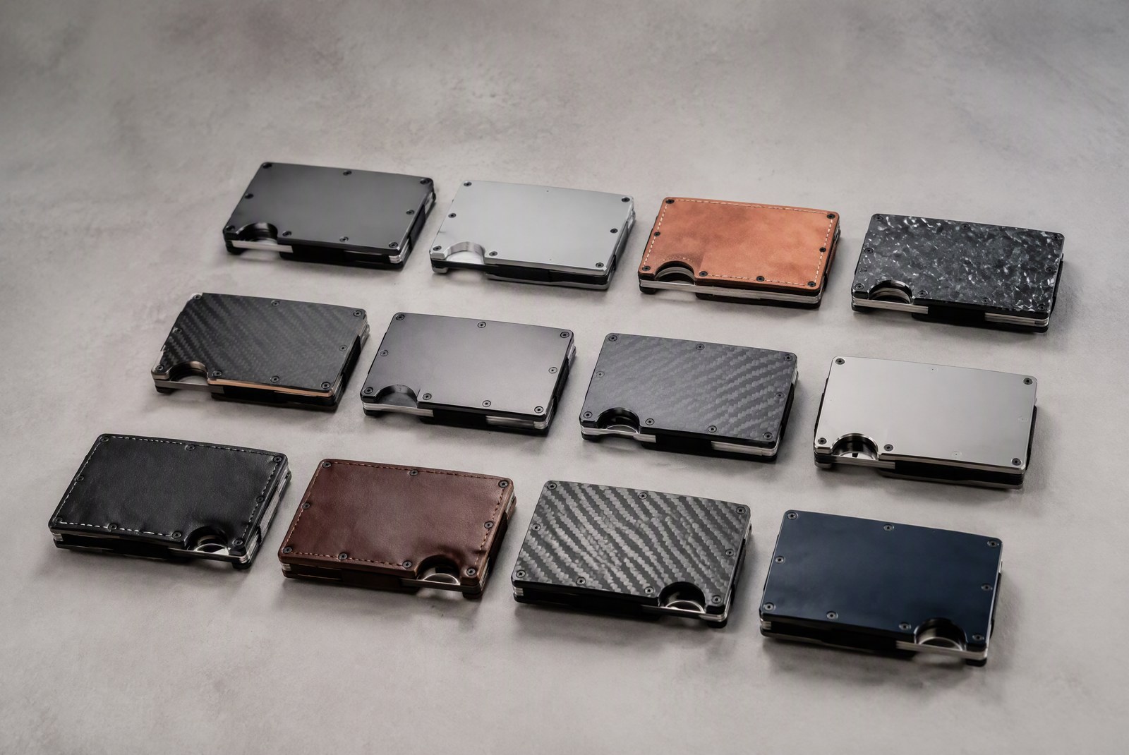 Close-up split view of wallet materials: brushed aluminum plates, full-grain leather swatches, titanium sheets, and carbon fiber weave on a work table