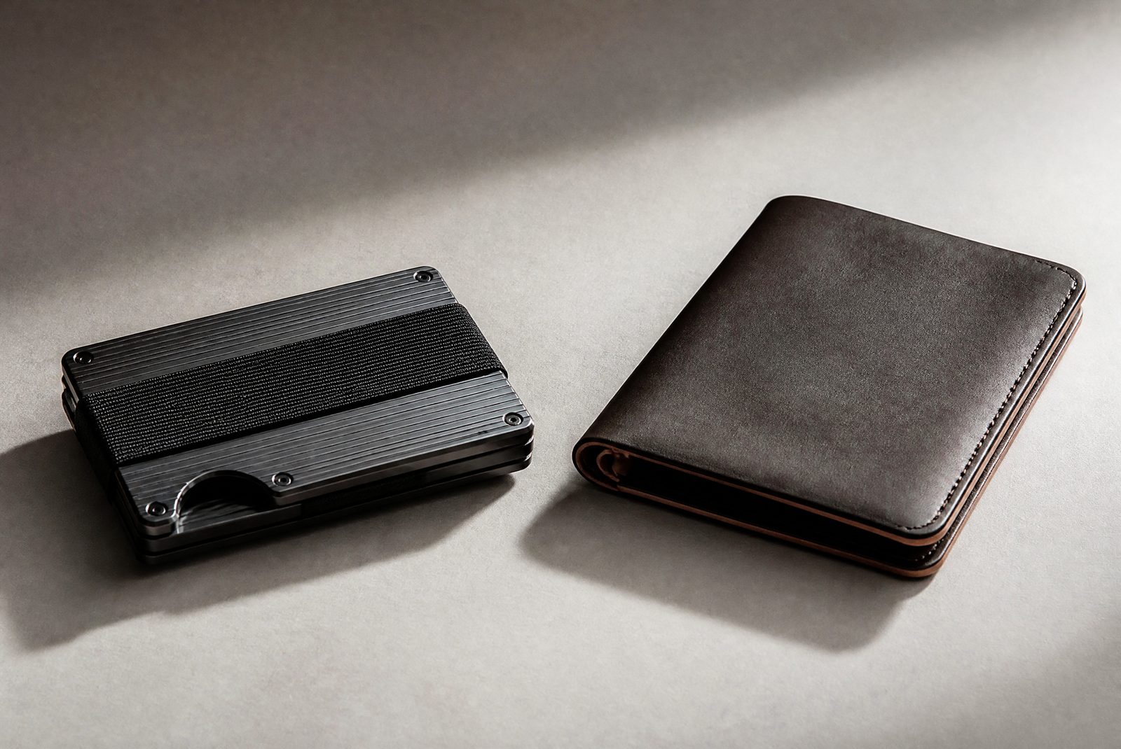 Ridge-style aluminum wallet next to a Bellroy-style leather wallet on a neutral surface