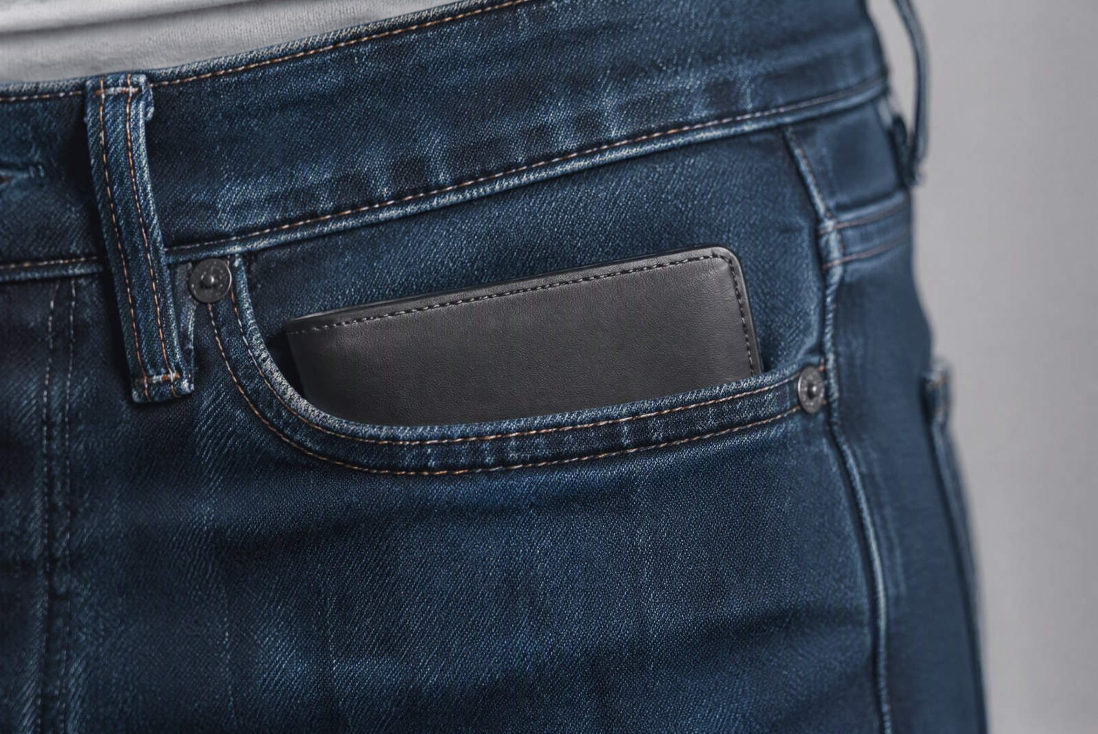 Slim aluminum card case and leather minimal wallet lying flat, ruler showing a millimetre-thin profile