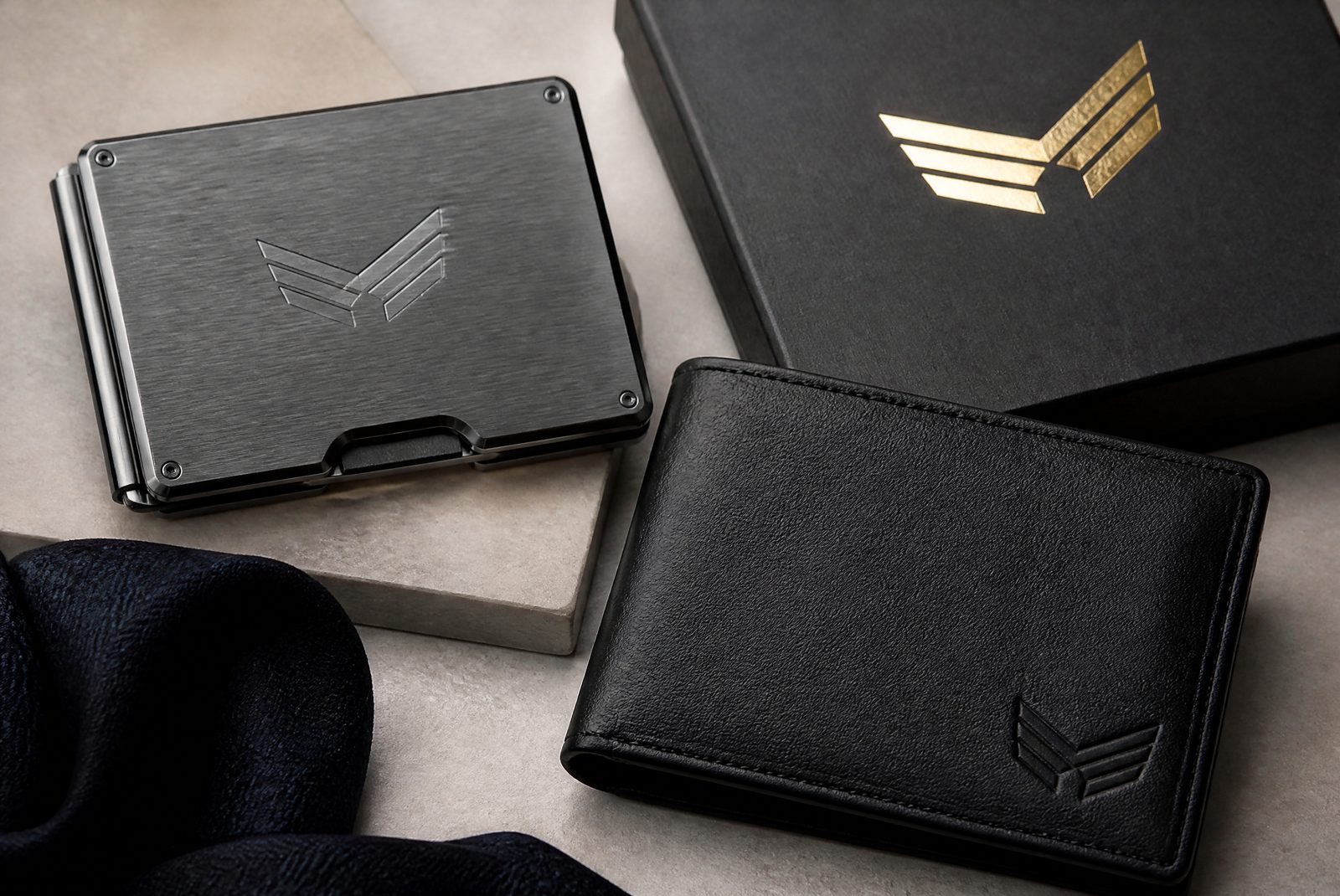 Multi-method branding: engraved, debossed and foiled logos across a leather and metal wallet set